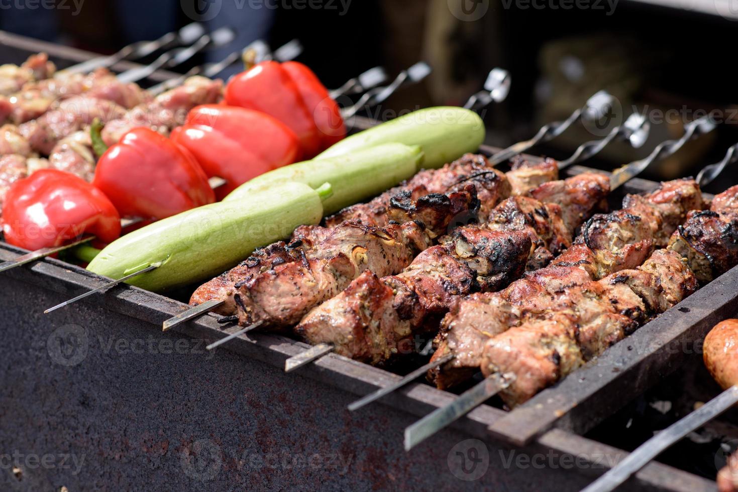 Gegrilde spiesjes van vlees op de kolen, met rook. straatvoedsel. foto