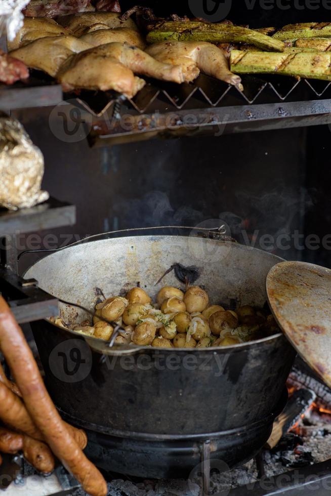 Brokken gebakken aardappelen in een grote koekenpan tijdens het straatvoedselfestival. foto