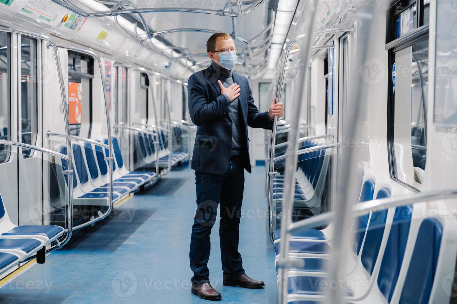 coronavirus (COVID-19. zieke man voelt zich onwel, ademt te kort, draagt medisch masker, poseert in metrowagon, beschermt tegen besmettelijke ziekte, vermijdt contact met mensen en virussen foto