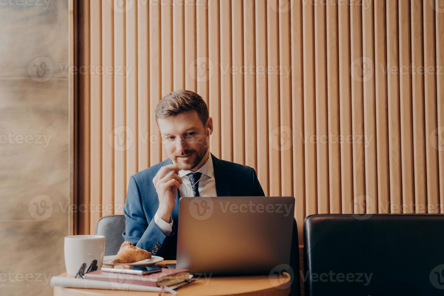 mannelijke officemanager tijdens online vergadering zittend in café foto