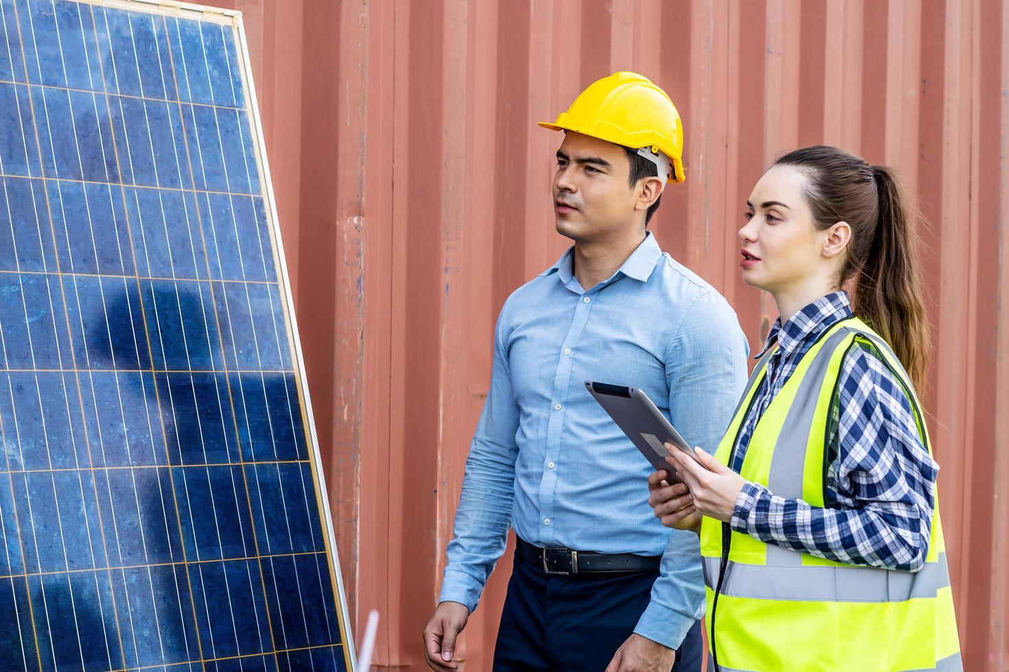 mannelijke energie-ingenieurs met zijn vrouwelijke collega-team bespreken nieuw project dat op het punt staat te investeren in het installeren van zonnecellen buiten het gebouw of de industriële fabriek foto