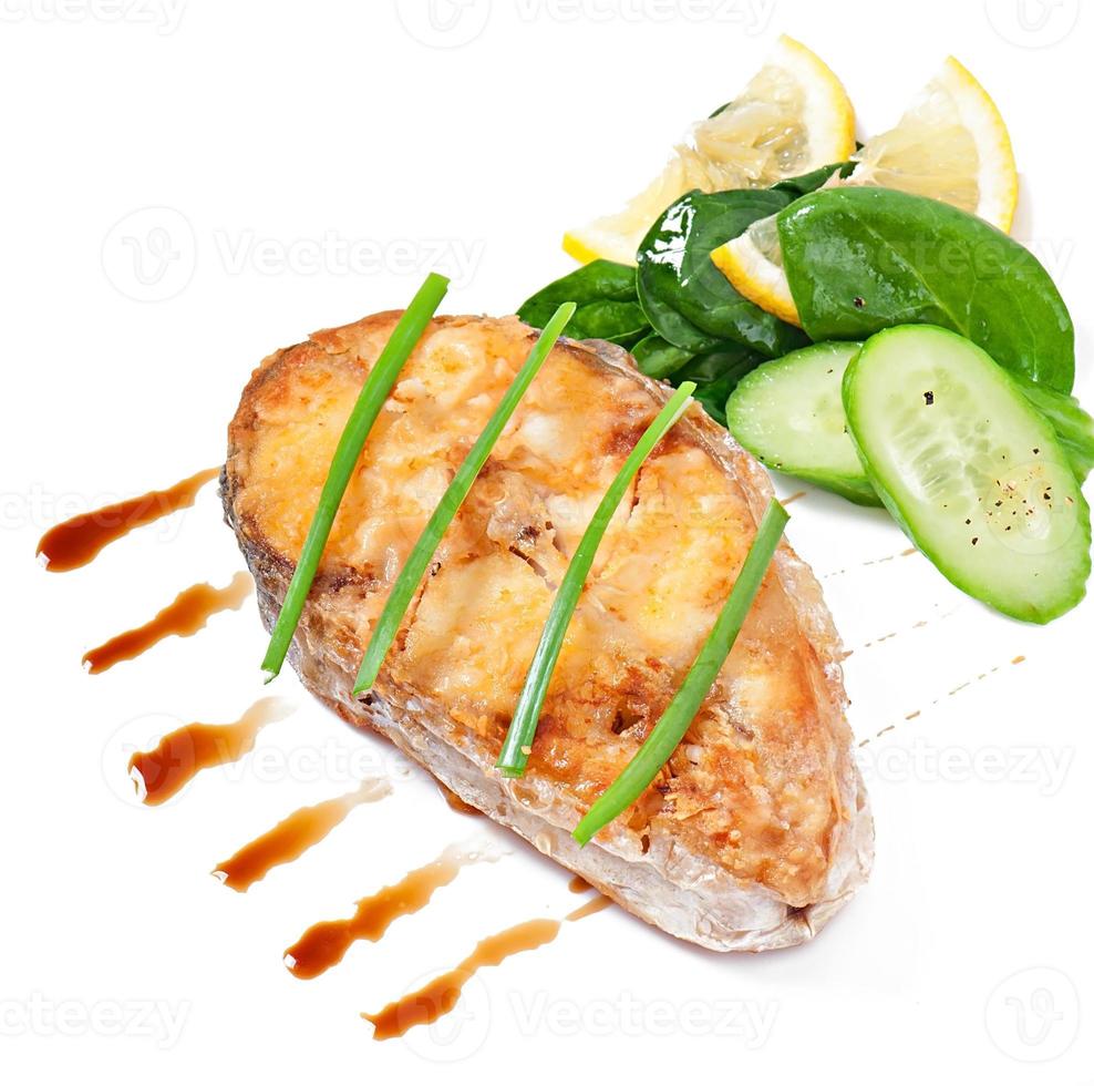 Visschotel - gebakken visfilet met groenten op witte achtergrond foto