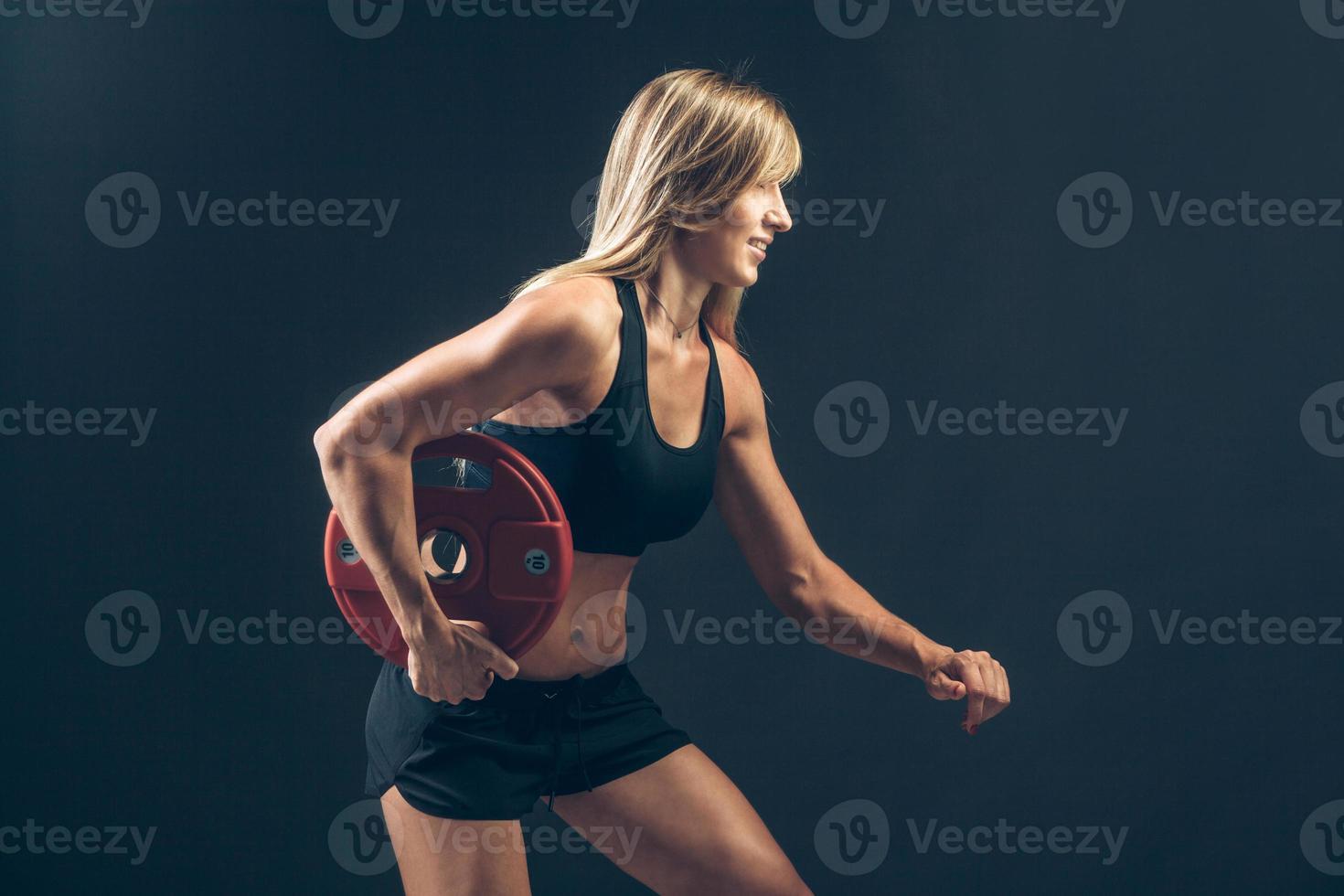 fitness vrouw die gewichtheffen doet door zware gewichten op te heffen foto
