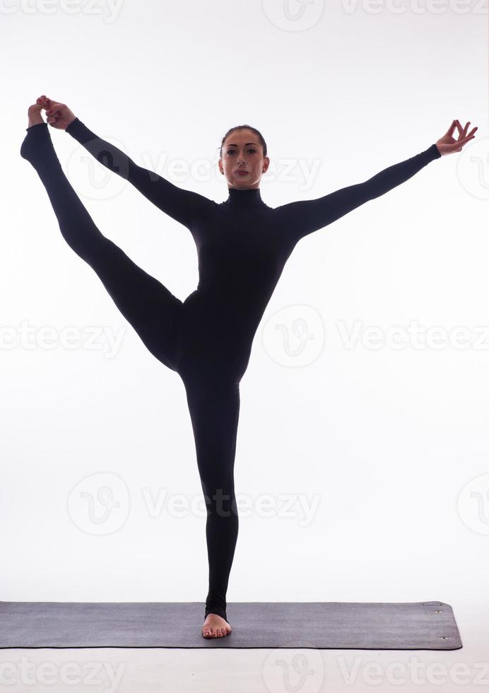 jonge mooie yoga vrouw poseren op een studio achtergrond foto