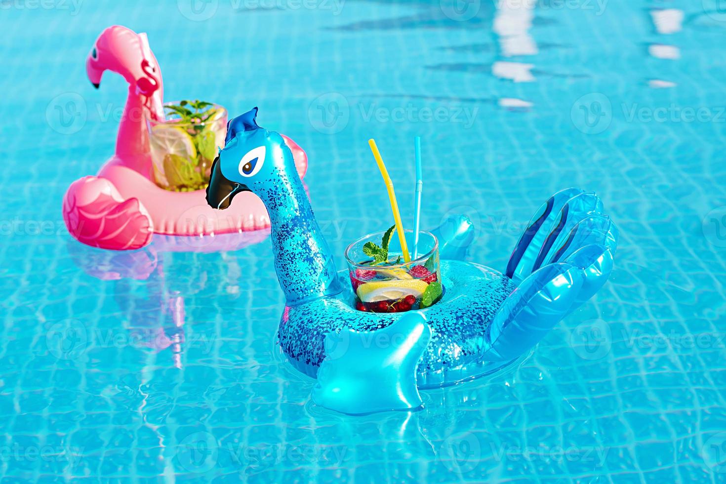 verse cocktailmojito op opblaasbaar stuk speelgoed bij zwembad. vakantie concept. foto