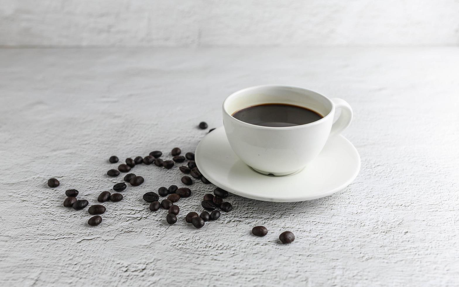 koffiekopje met koffiebonen op witte achtergrond foto