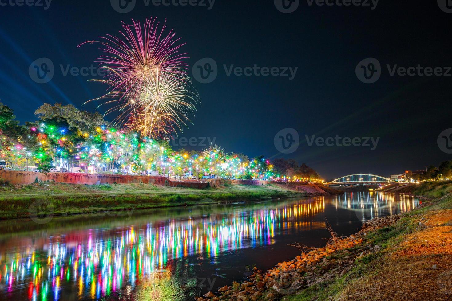 vuurwerk aan de waterkant met lichten in phitsanulok, thailand. foto