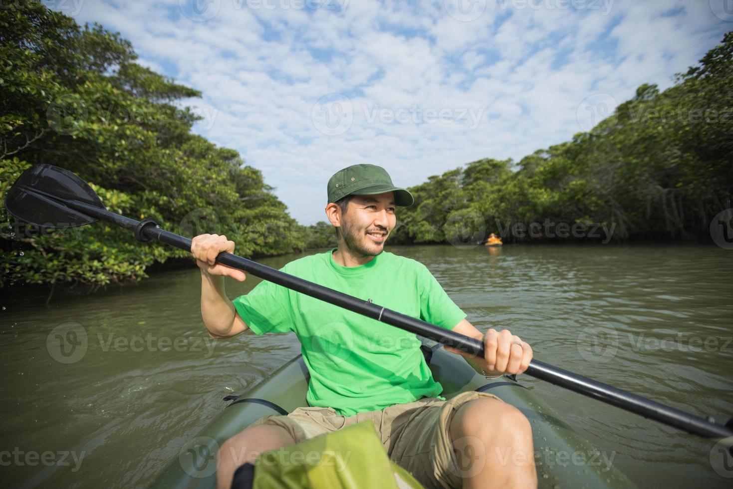 man genieten van rivier kajakken in mangrovebossen, japan foto