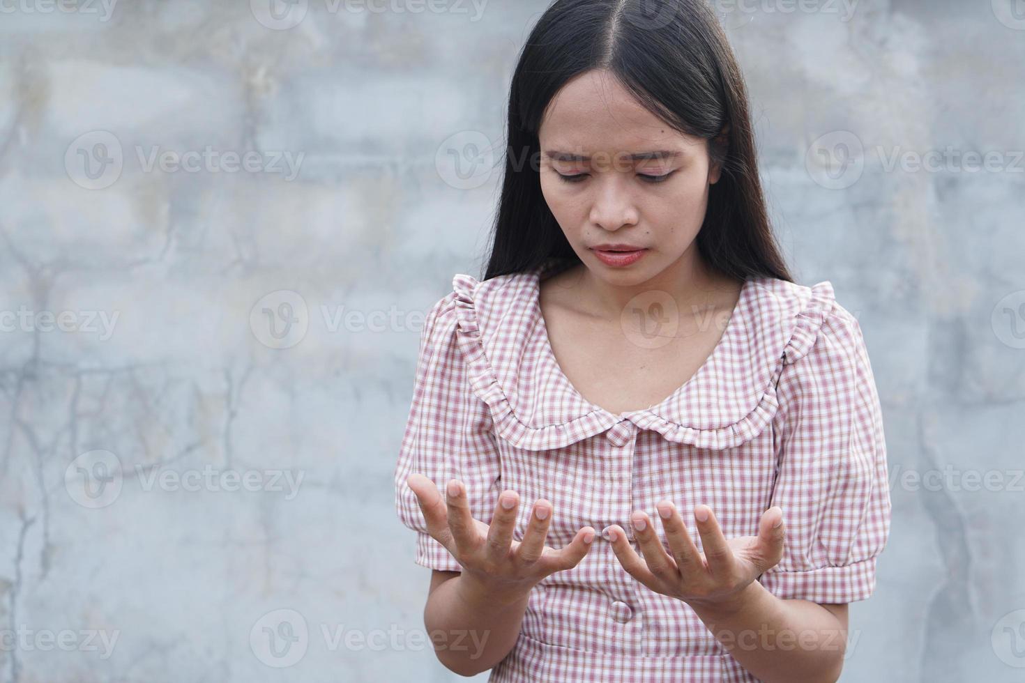 vrouw die naar haar handen kijkt foto