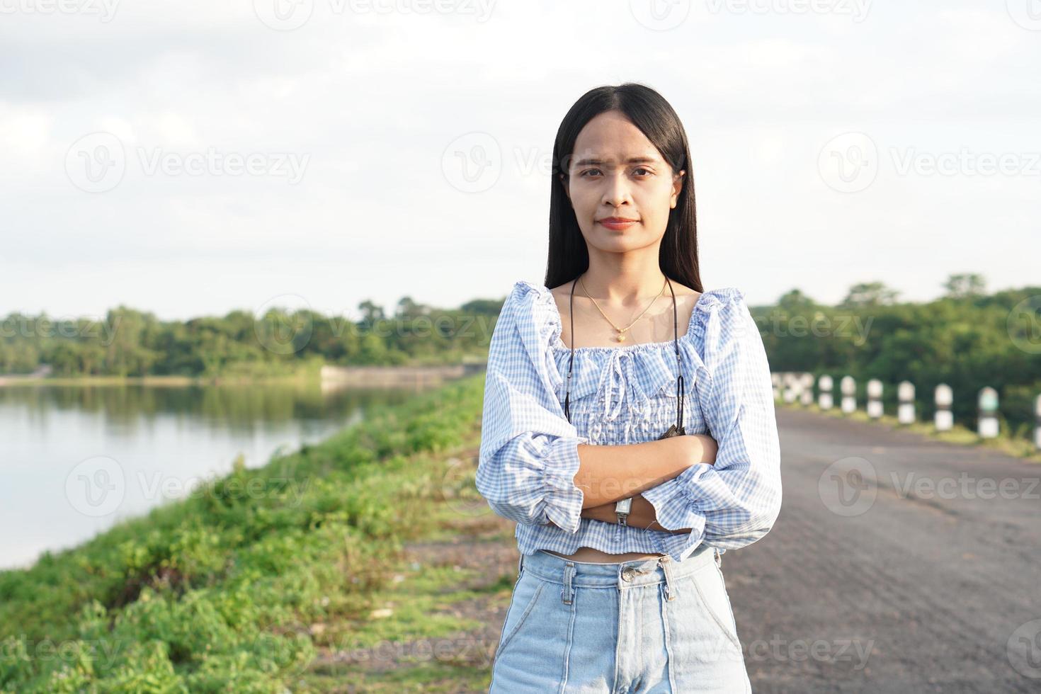 aziatische vrouw in een lichtblauwe jurk loopt vrolijk over de weg foto