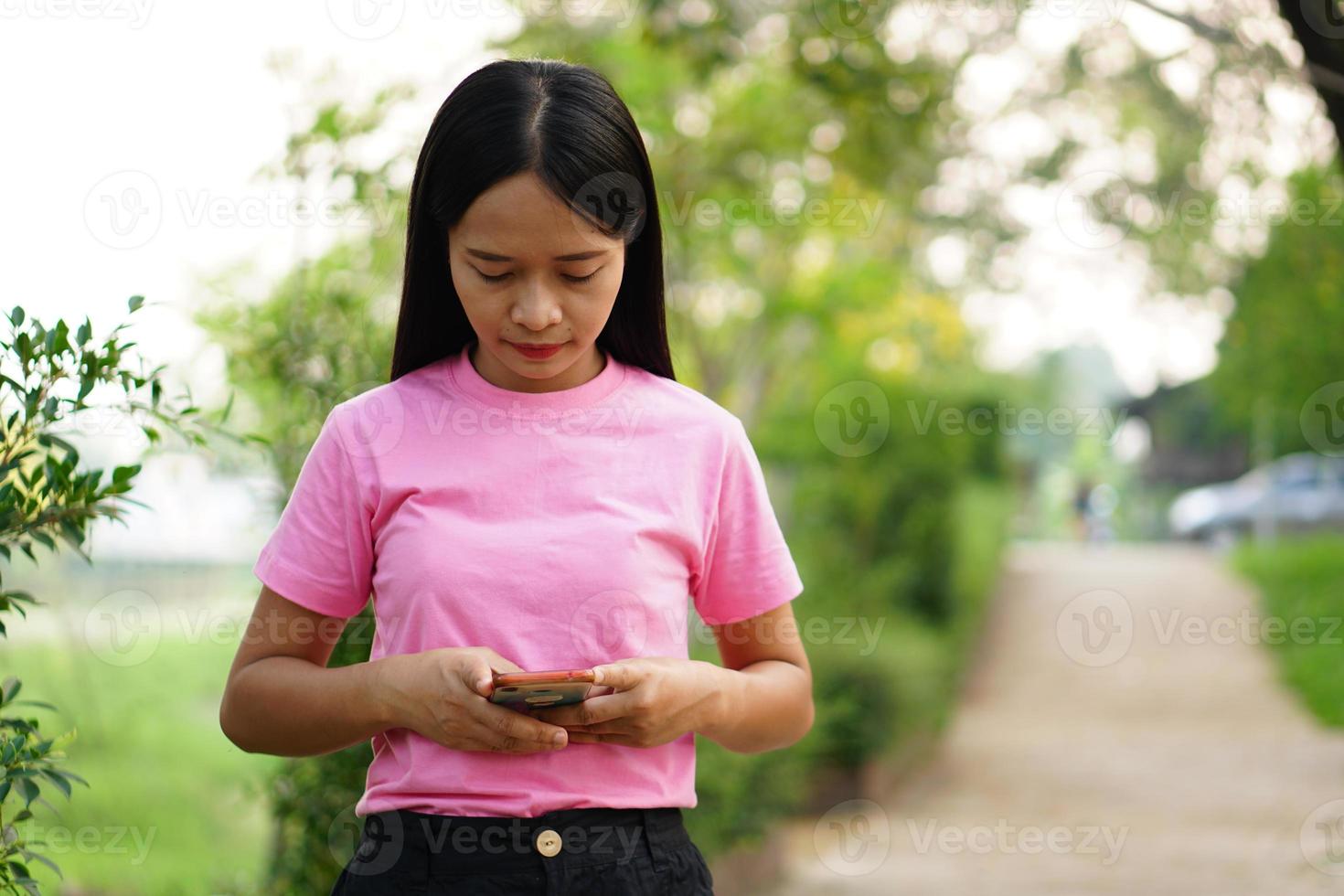 aziatische vrouw die telefoon in park gebruikt foto