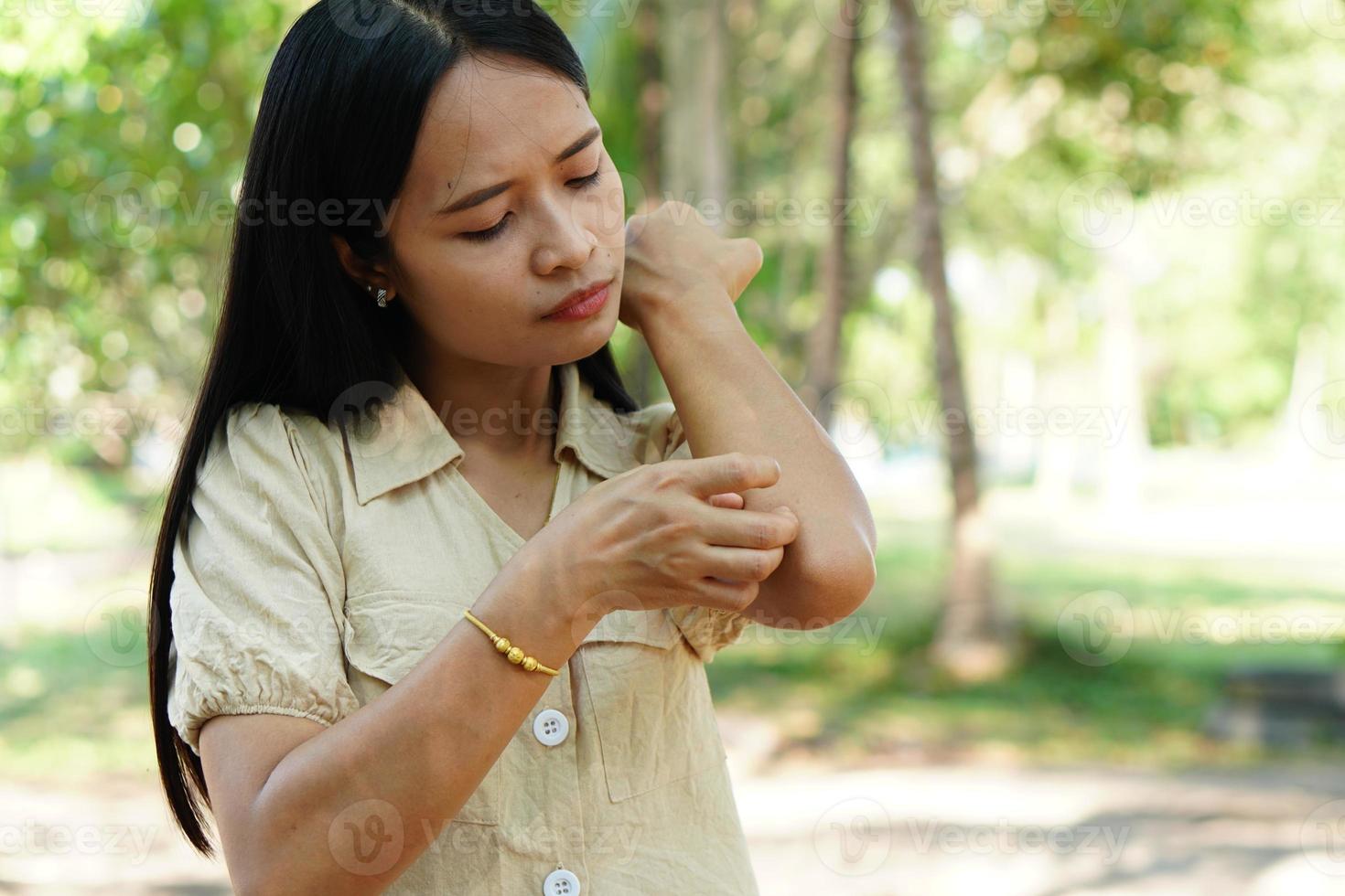 vrouw krabt arm van jeuk foto