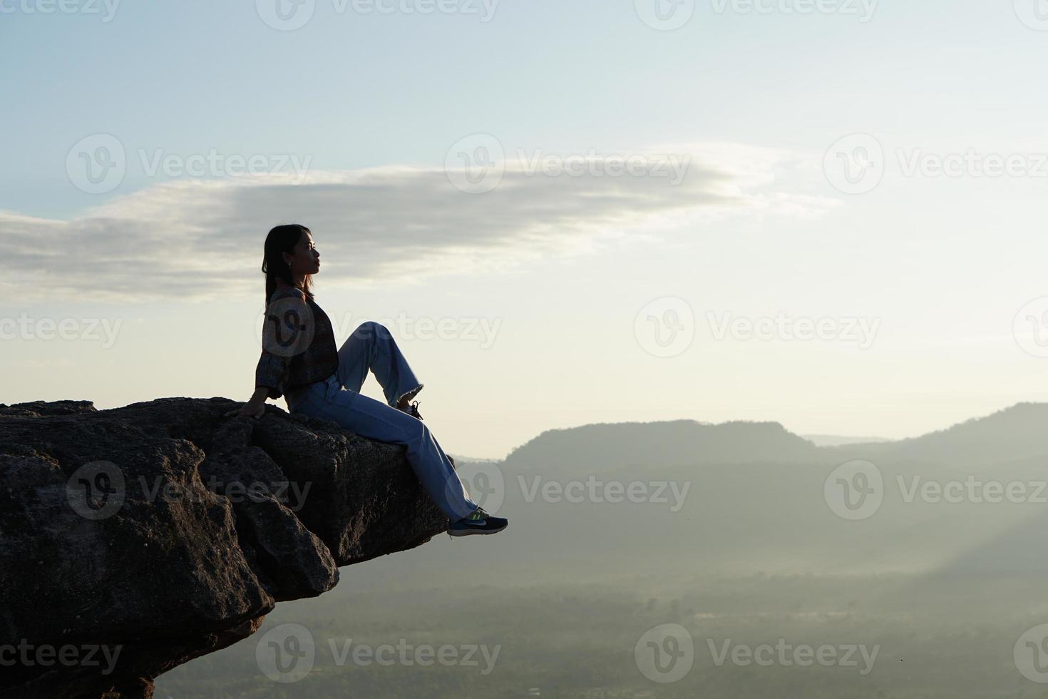vrouwelijke toerist op de berg die naar de natuur kijkt foto