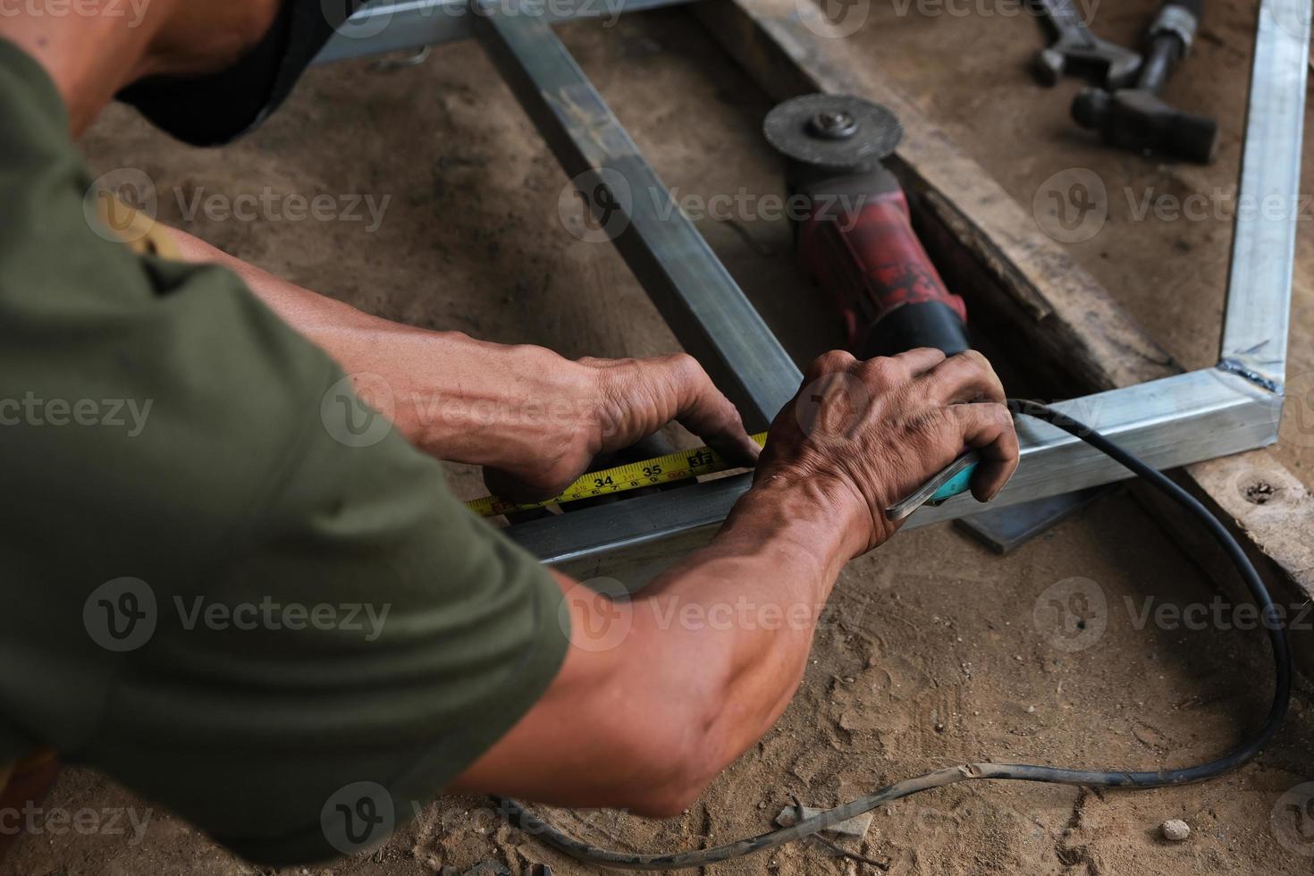 een man werkt als lasser in een plaatselijke reparatiewerkplaats foto