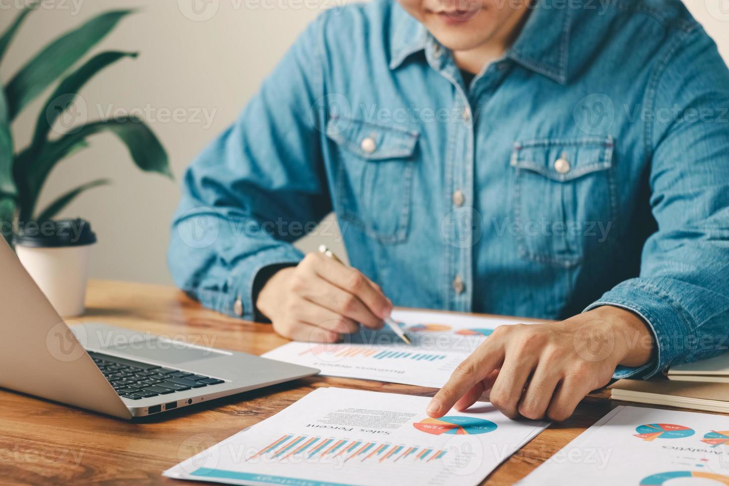 mannelijke leidinggevende die zakelijke verkoopprestaties analyseert en plant op basis van financiële gegevens, financiële verkoopgegevens en economische groeigrafiek analyseert. foto