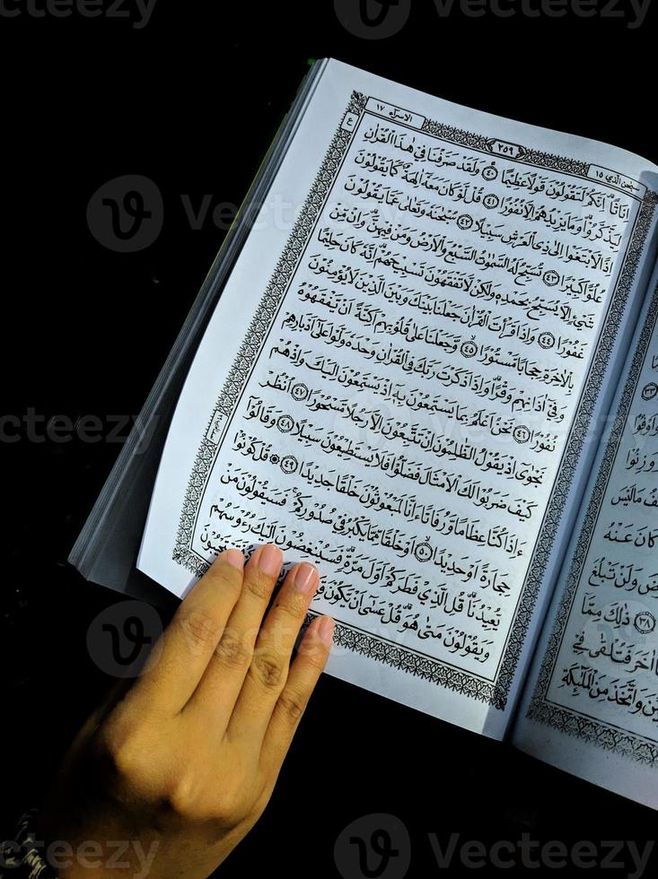 man die de koran vasthoudt en leest. islamitische achtergrond foto