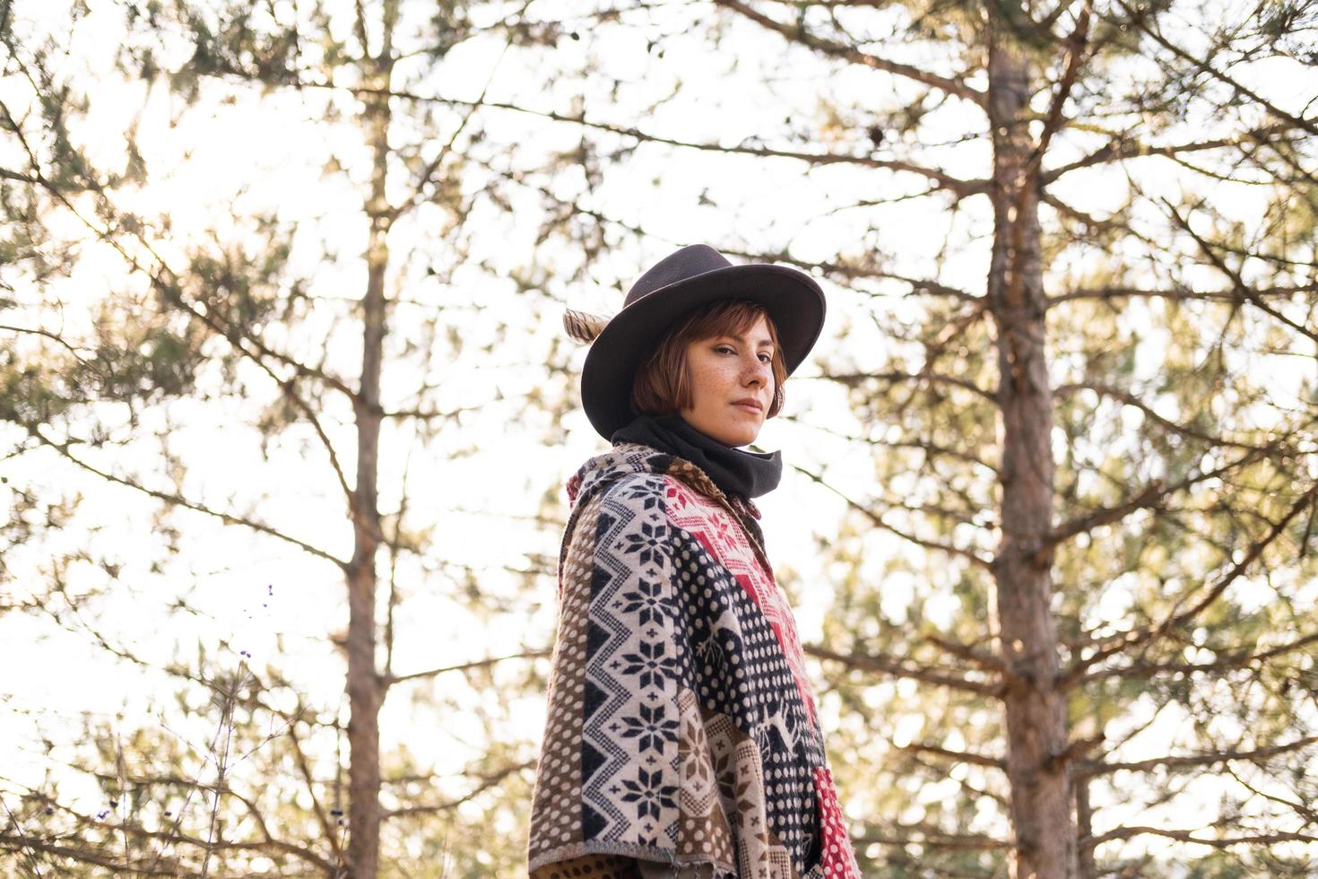 yong hipster vrouw reiziger in hoed en poncho buiten wandelen foto