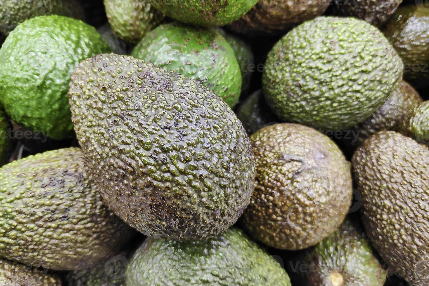 stapel avocado's op een marktkraam foto