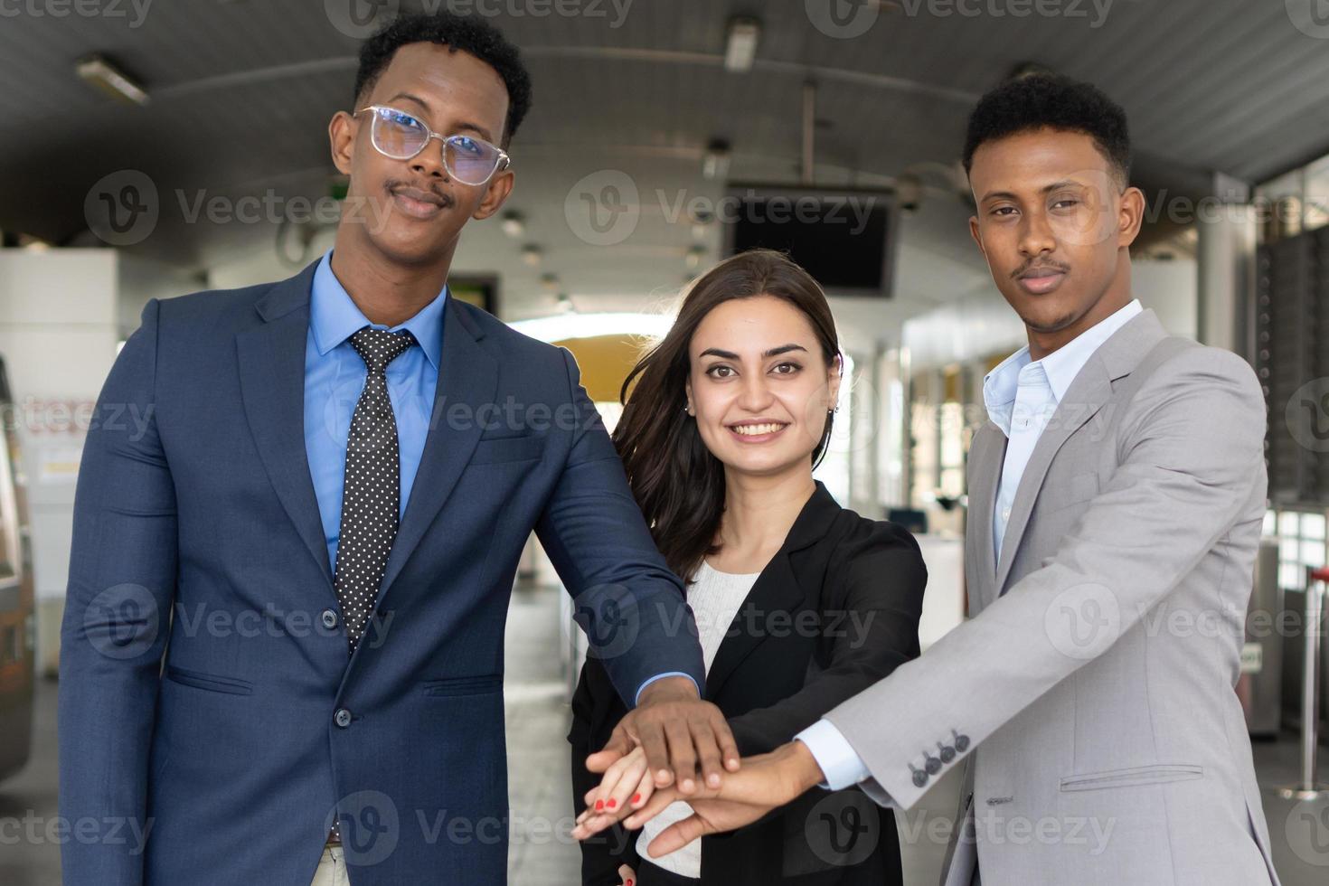 groep zakenmensen die met hun handen bij elkaar staan. succes en winnend concept - gelukkig business team dat de overwinning op kantoor viert. close-up van zakenmensen die hun handen in elkaar slaan. foto