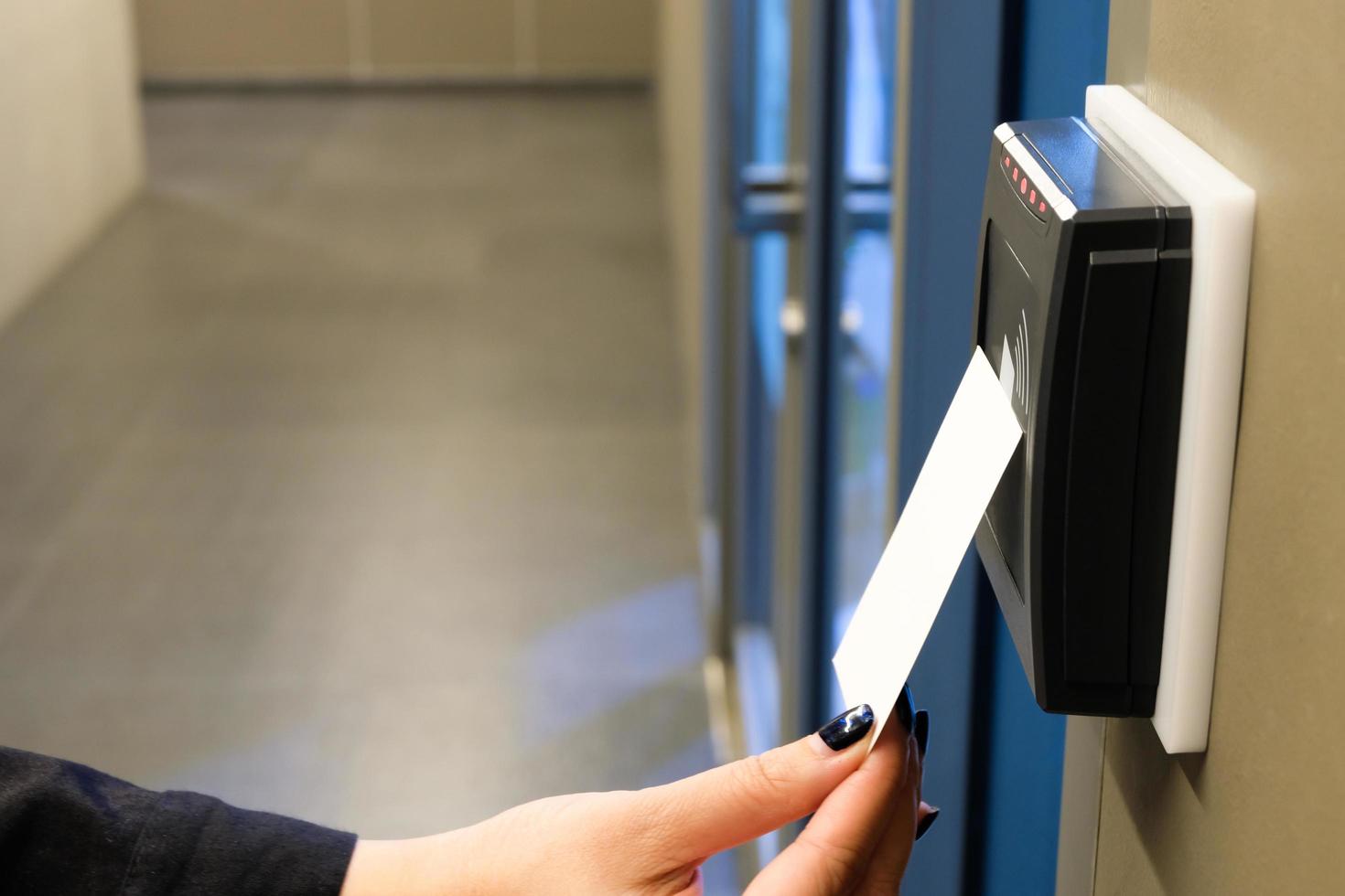 vrouwen hand reiken om rfid-sleutelkaart te gebruiken voor toegang tot kantoorgebouw en werkruimte. in gebouwbeveiliging alleen voor geautoriseerde persoon foto