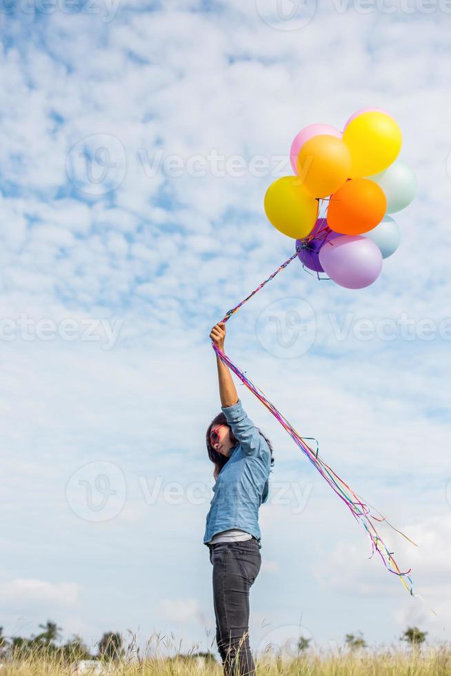 mooi meisje springen met ballonnen op het strand foto