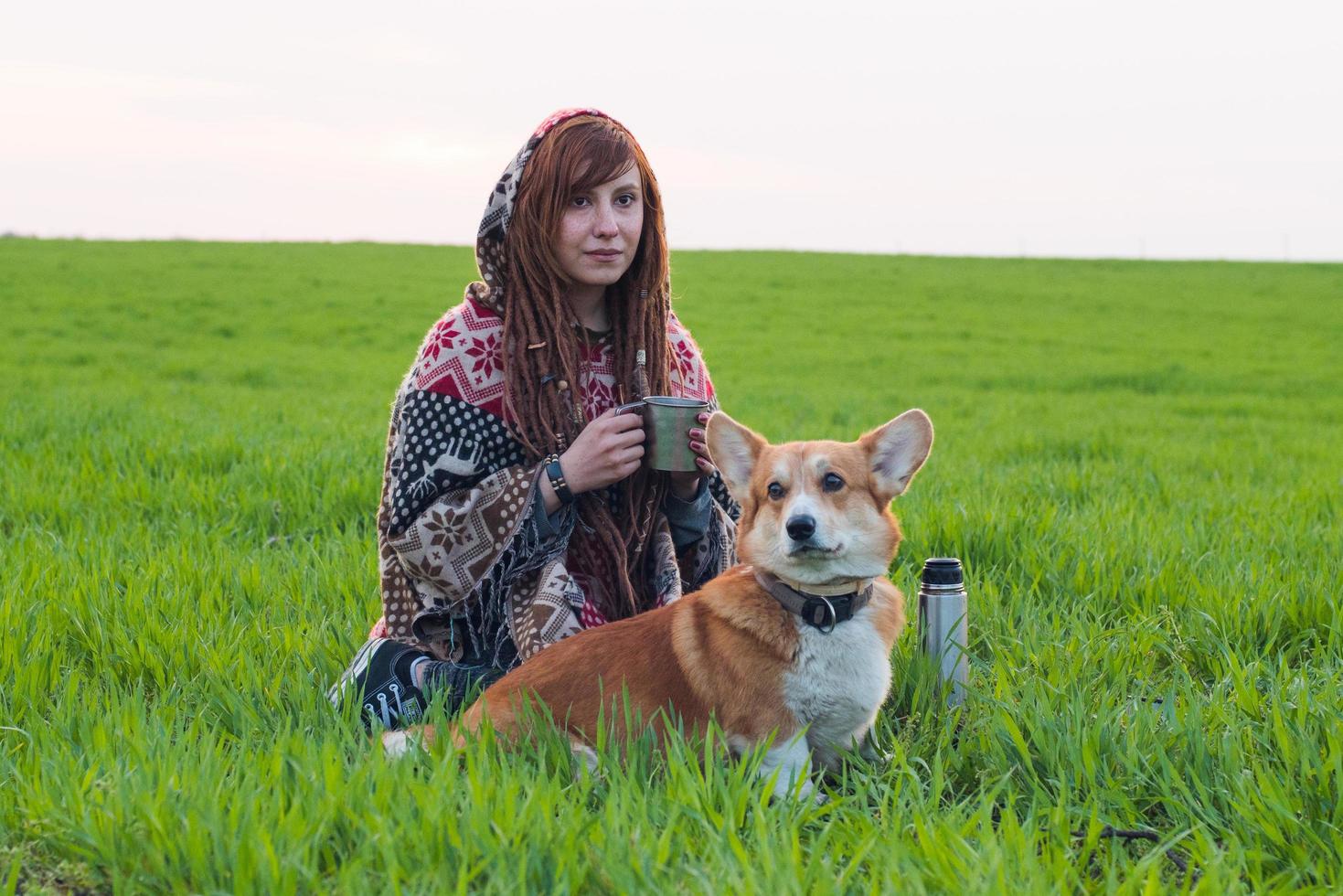 jonge vrouw met corgi in het voorjaarsveld foto