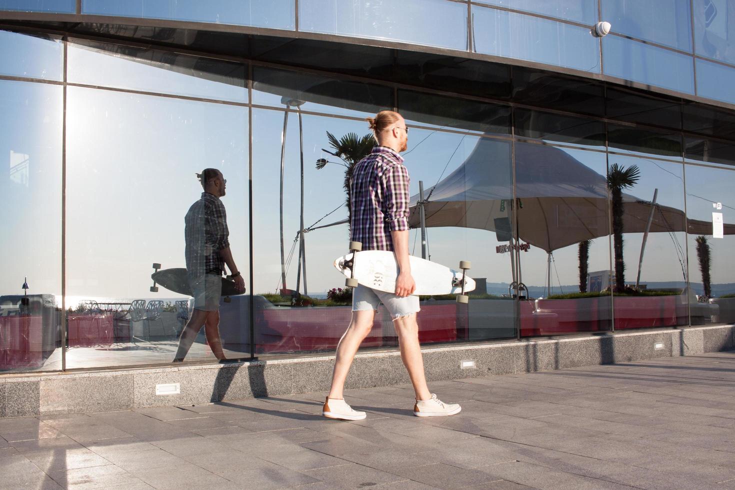 jonge bebaarde skater op stadsstrand foto