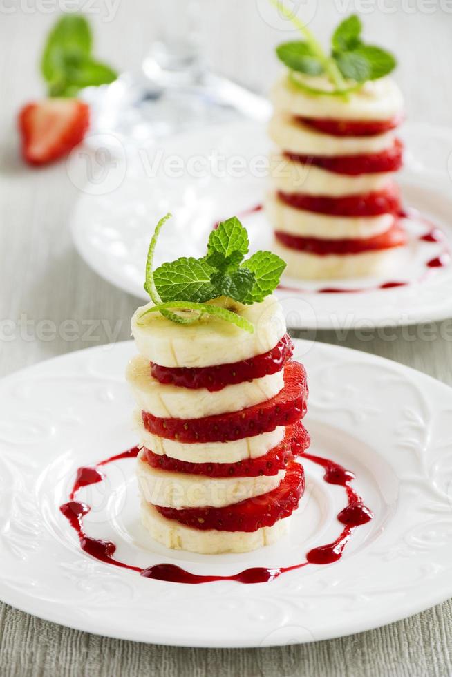 dessert van aardbeien en bananen met fruitsaus. foto