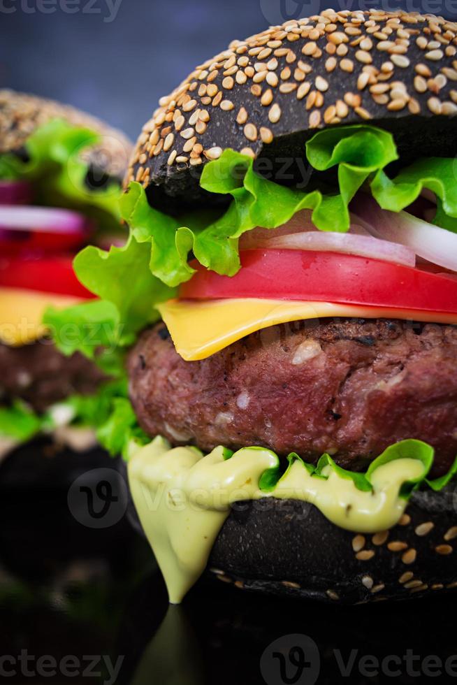 handgemaakte hamburger op donkere achtergrond. heerlijke zwarte burger foto