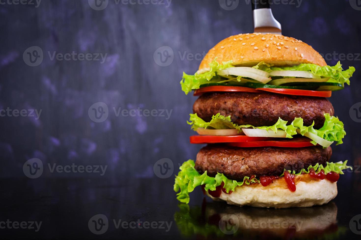 heerlijke handgemaakte hamburger op donkere achtergrond. dichtbij bekijken foto