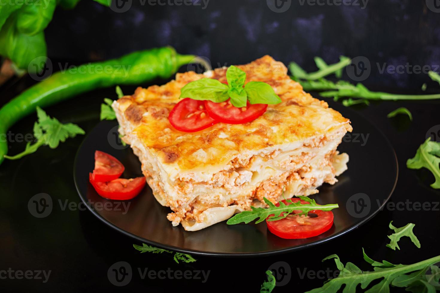 klassieke lasagne met bolognesesaus op donkere achtergrond foto