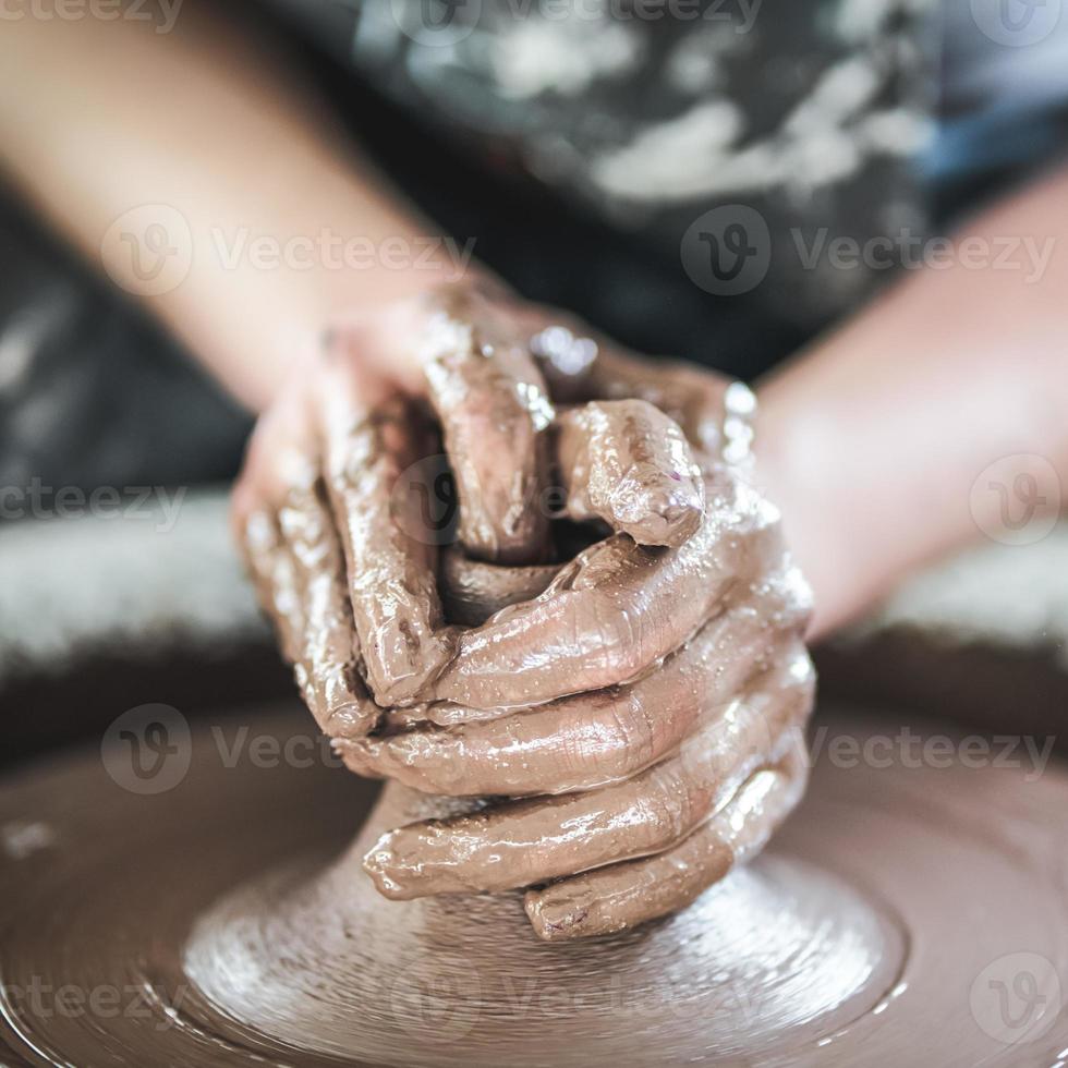 vrouw die keramisch aardewerk op wiel maakt, handen close-up, creatie van keramiek foto