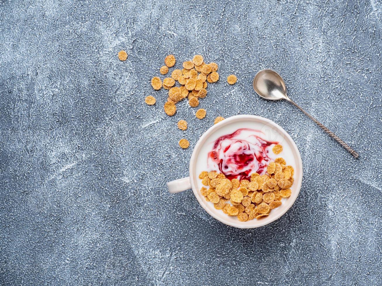 Griekse yoghurt met jam in witte kom op grijsblauwe betonnen stenen tafel, bovenaanzicht, kopieerruimte foto