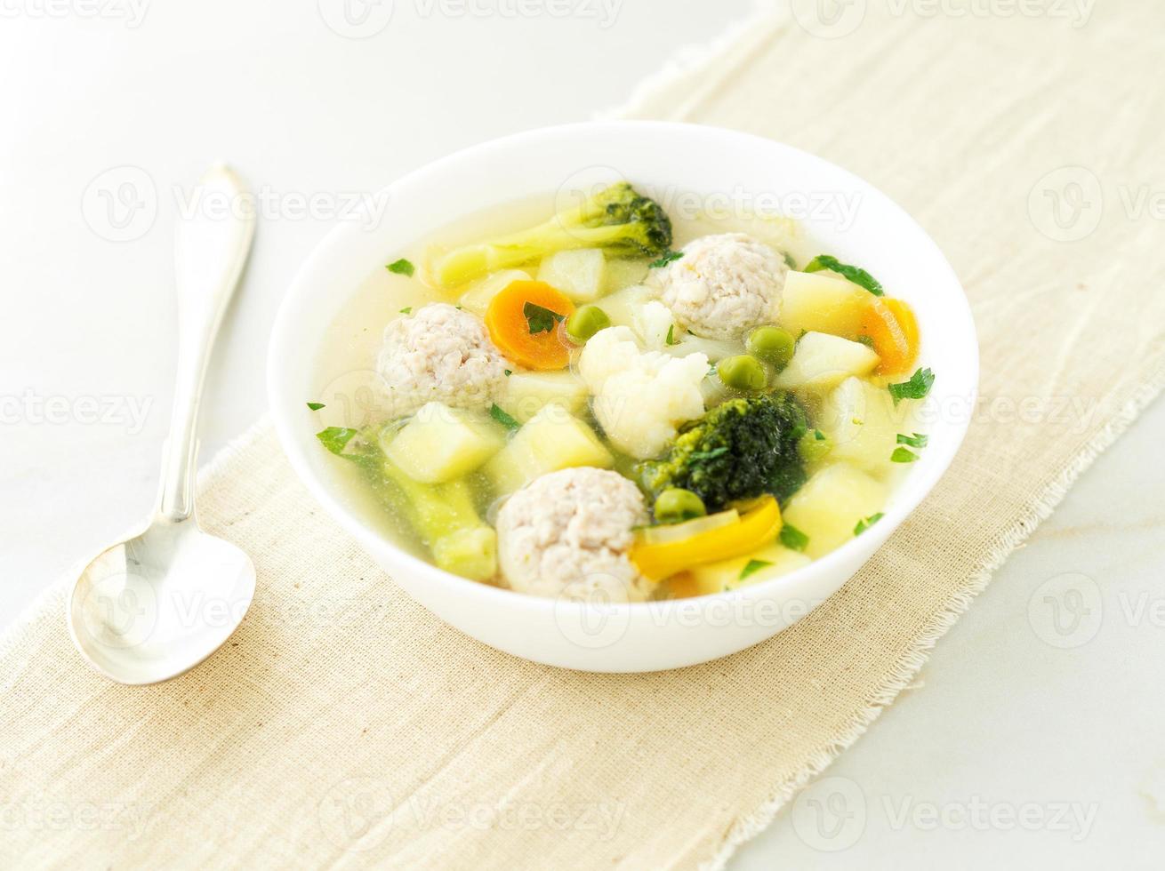 kom soep, een kopje bouillon en groenten, gehaktballen gemaakt van kalkoen en kip, zijaanzicht foto