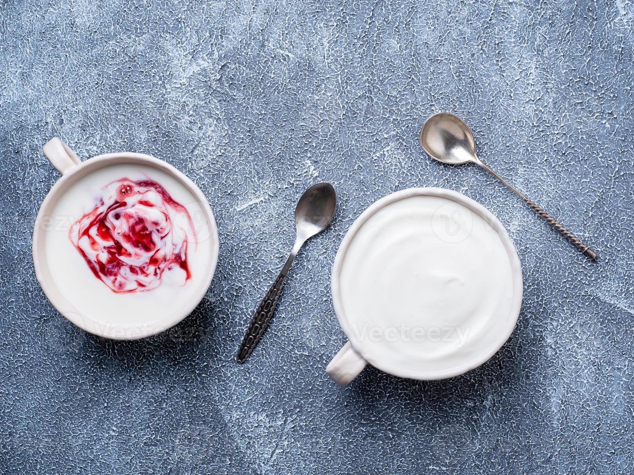 twee Griekse yoghurt in witte kom op grijsblauwe betonnen stenen tafel, bovenaanzicht foto