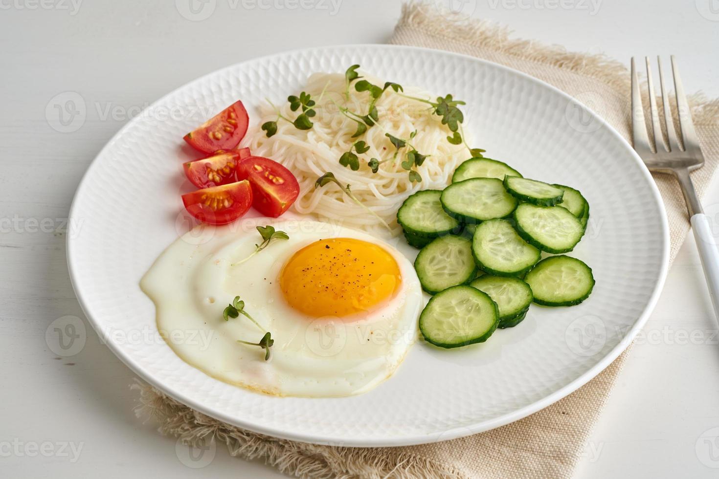 gezond ontbijt - gebakken ei met kerstomaatjes en komkommer op lichte witte achtergrond, fodmap dash dieet, glutenvrij, zijaanzicht close-up foto