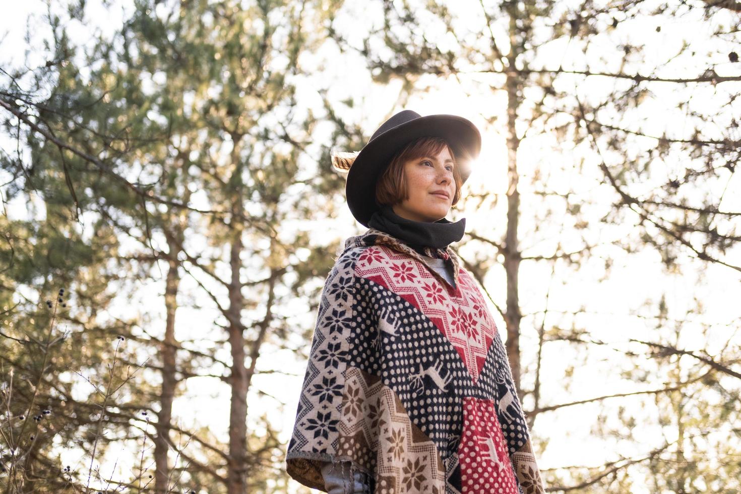 yong hipster vrouw reiziger in hoed en poncho buiten wandelen foto