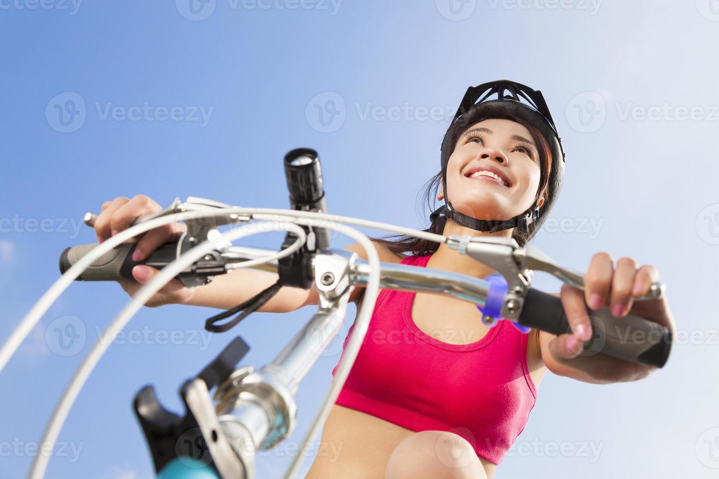 vrouwelijke fietser die met blauwe hemel begint te rijden foto