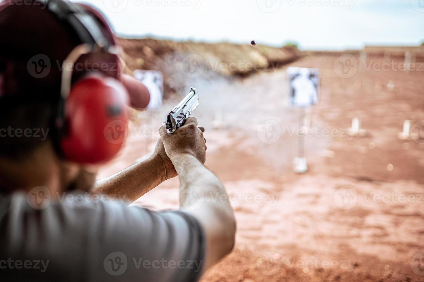 detailweergave van schutter die pistool vasthoudt en tactisch schieten traint, focus op pistool. schietbaan. foto