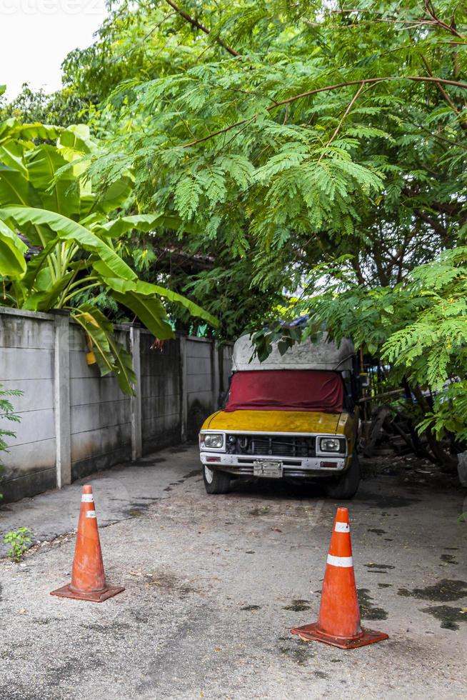 verlaten oude auto in het tropische bos in bangkok thailand. foto