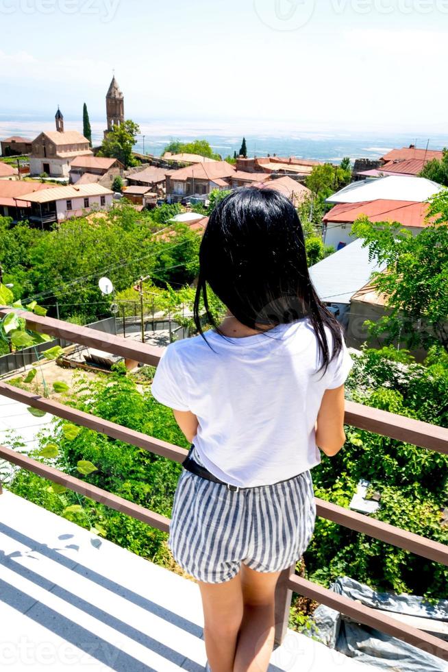 jonge blanke vrouw kijkt uit over een panoramisch uitzicht op de historische gebouwen van sighnagi foto