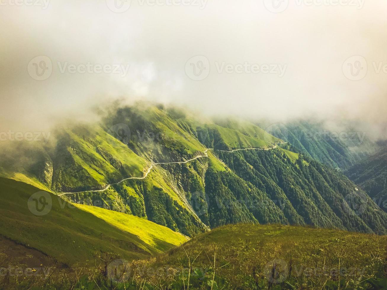 filmisch verbluffend tusheti-wegpanorama met mist en groen landschap. Georgische extreme tours avontuurlijke reizen foto