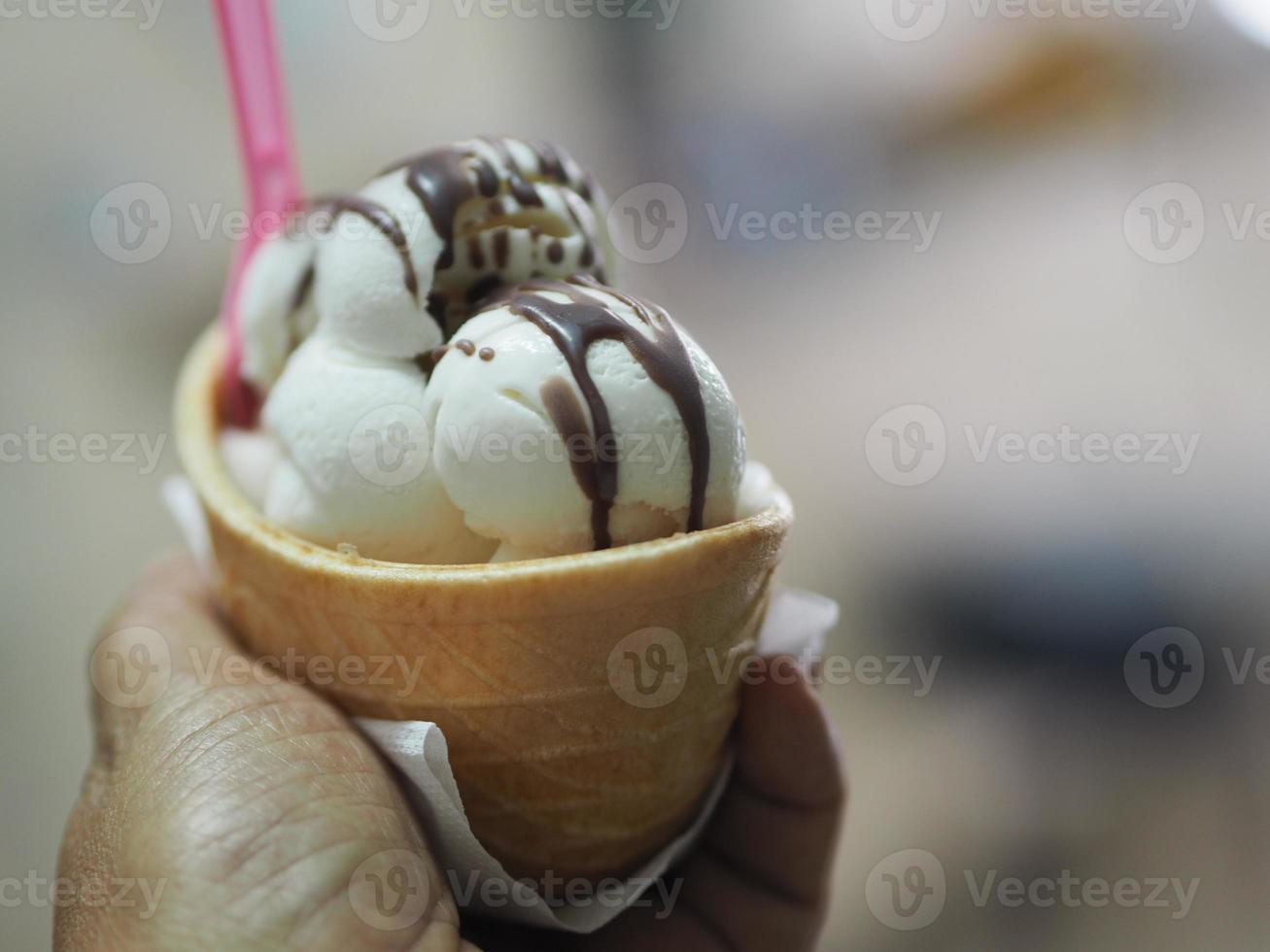 Kokosmelkroomijs in een krokante wafelbeker in vrouwenhand foto