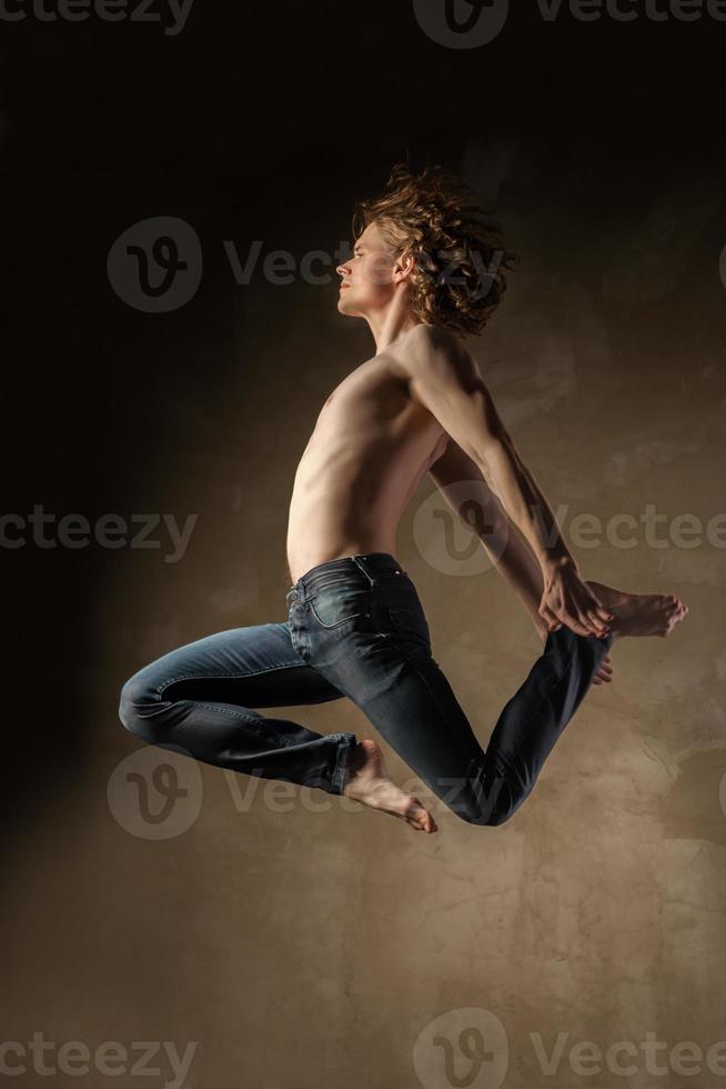 jonge en stijlvolle moderne danser op grijze achtergrond foto