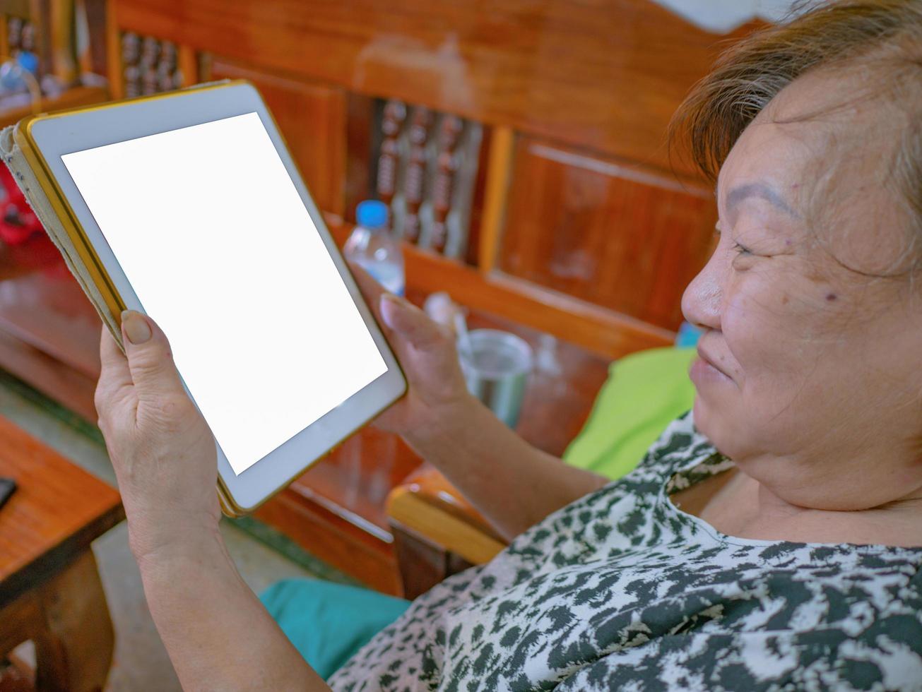 oude Aziatische vrouwen kijken erg blij naar de tablet foto