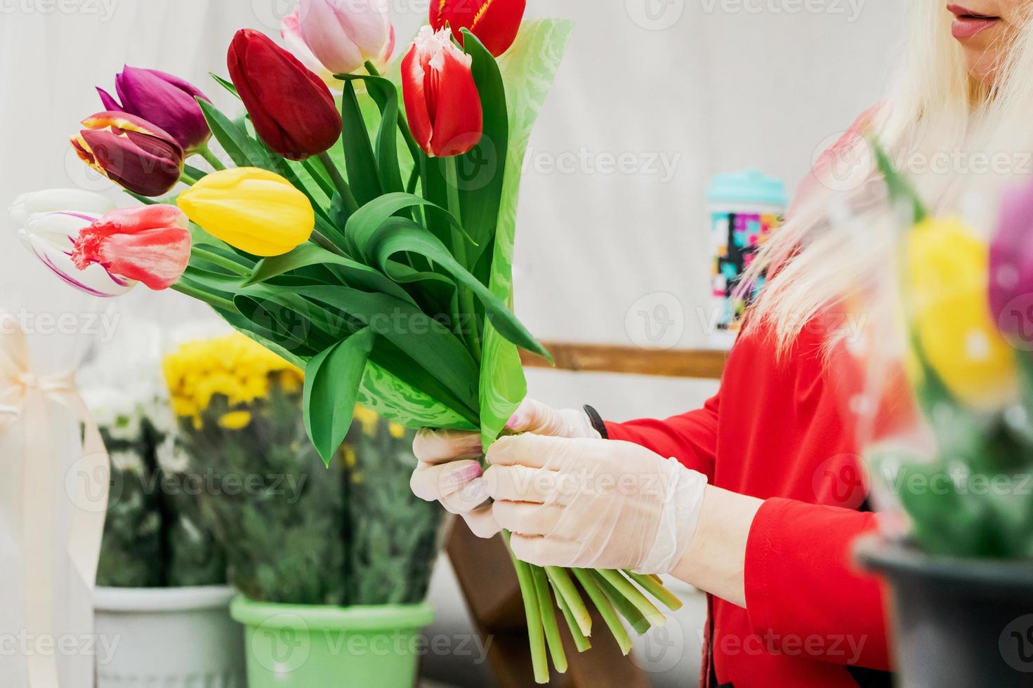 vrouw bloemist maakt boeket verse tulpen. handen houden lentebloemen. foto