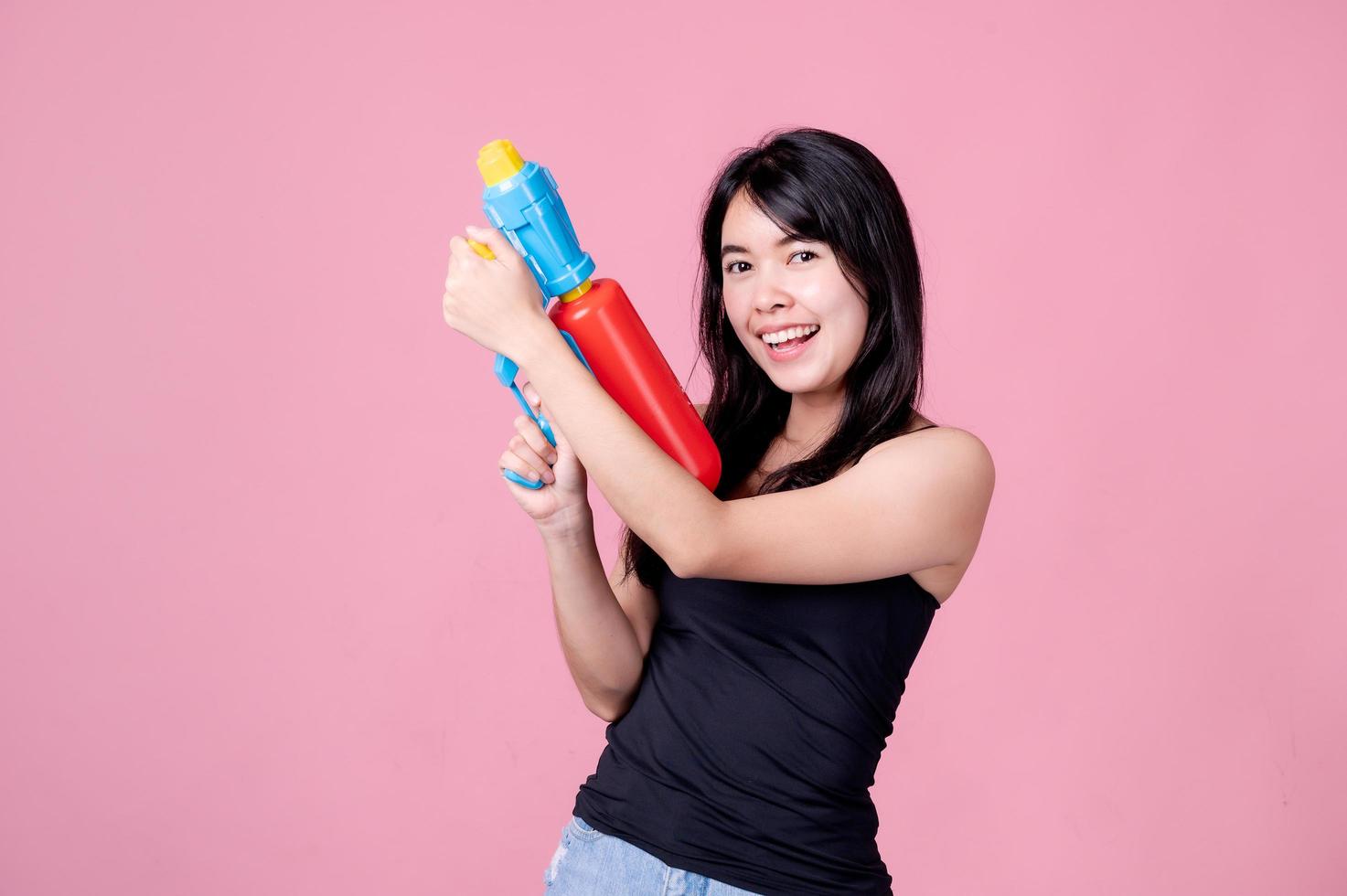 mooie aziatische vrouwen houden plastic waterpistolen vast bij een oude tempel tijdens songkran, het mooiste en leukste waterfestival in thailand foto