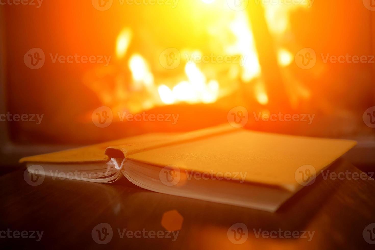 open boek op de achtergrond van een brandende open haard foto