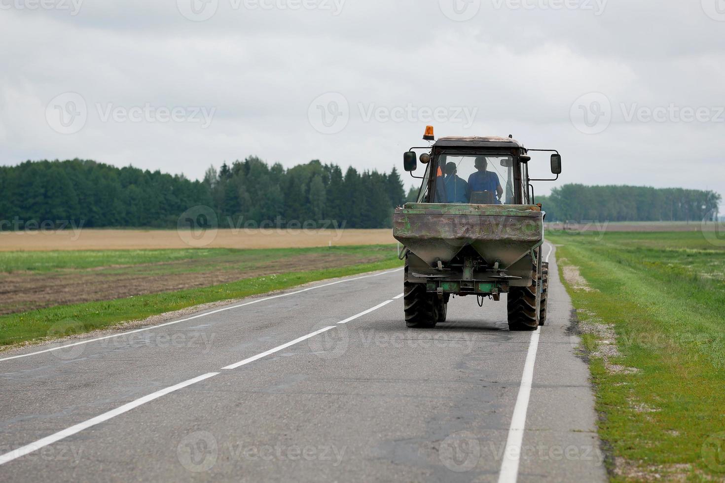 tractor rijdt op de weg achteraanzicht foto