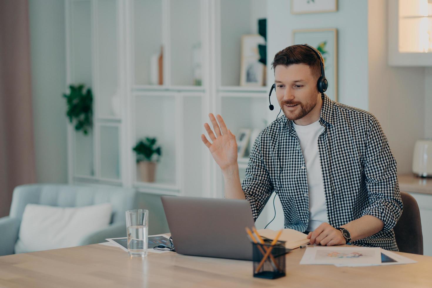 lachende jonge man aan het werk met laptop thuis foto